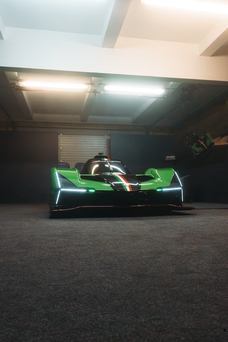 A sleek green and black race car indoors