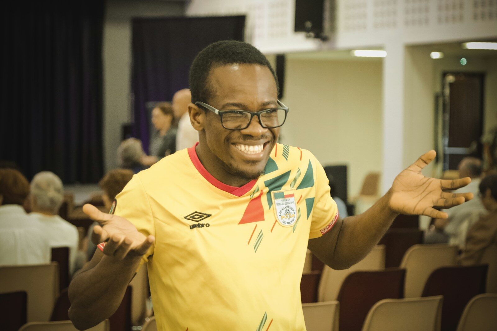 A man in a yellow shirt standing in front of a crowd Why Register a .com.ng Domain
